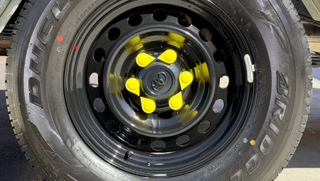 Close-up of a tire with  ACOT500 yellow wheel nut indicator on a vehicle